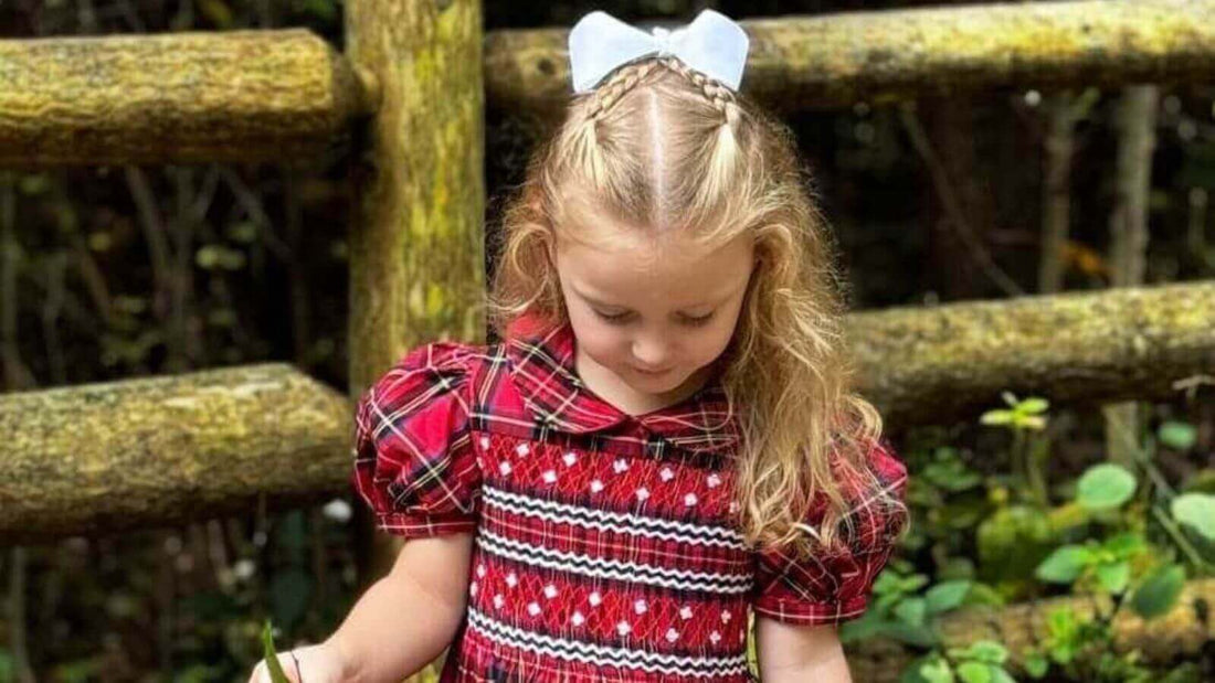 Little girl in a red smocked holiday plaid dress, perfect for festive photos.