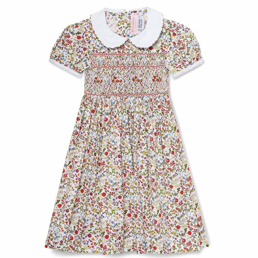 Hand-smocked English Garden Dress with floral print and white collar for young girls, perfect for summer memories.