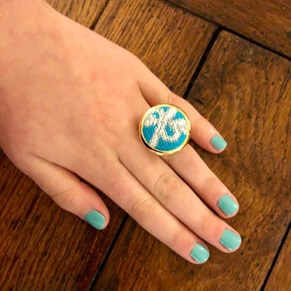 Hand showcasing the Iconic Blue Box Needlepoint Ring with teal accents, perfect for gifting and versatile style.