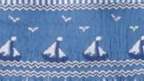 Hand-smocked blue fabric featuring sailboats and seagulls, perfect for the Smocked Sailboat John John.