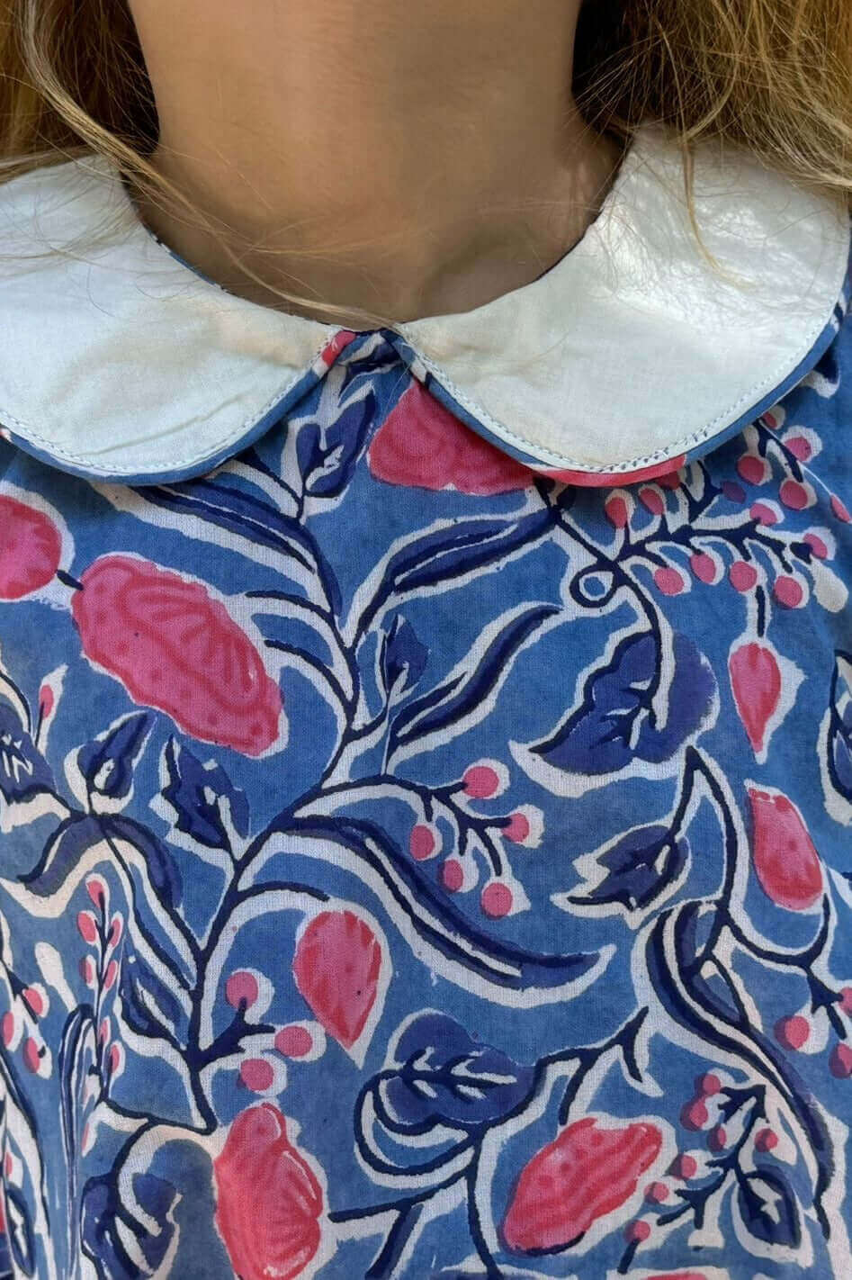 Close-up of a Sky and Pink Floral Dress with charming floral print and elegant white collar.