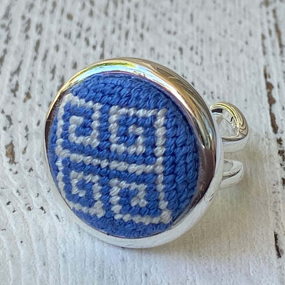 Stylish periwinkle blue Greek key needlepoint ring with silver adjustable band, perfect as a gift or accessory.