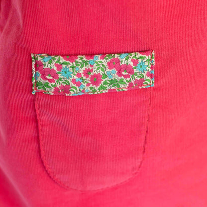 Liberty of London pink dress pocket with floral trim design, showcasing bright elegance and style for girls' fashion.