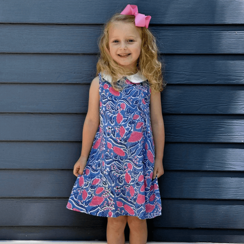 Little girl in a Sky and Pink Floral Dress with Peter Pan collar and pink bow, ready for back-to-school.