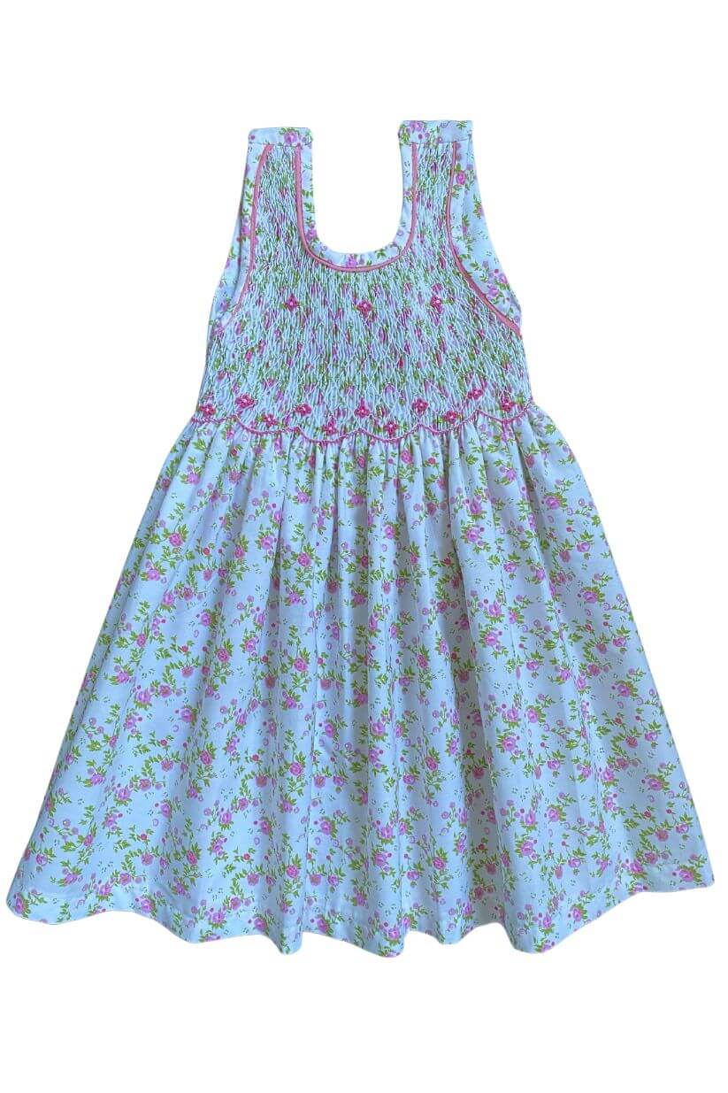 Hand-smocked pink and green floral dress perfect for spring, featuring delicate floral embroidery and crisscross back.