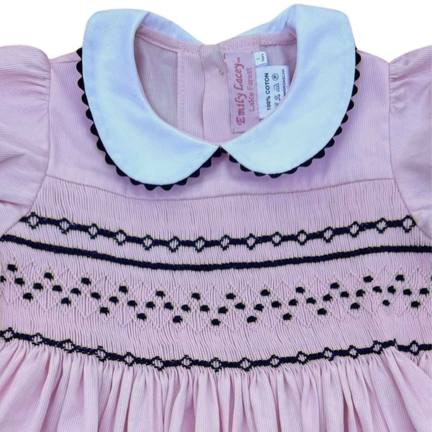 Smocked Pink and Navy Geo Dress with white collar and navy ric rac trim showcasing detailed hand-smocking and elegant design.