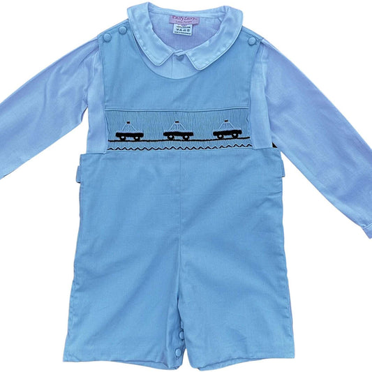 Hand-smocked blue police car John John outfit with covered buttons and blue trim, perfect for preschool photos and everyday wear.