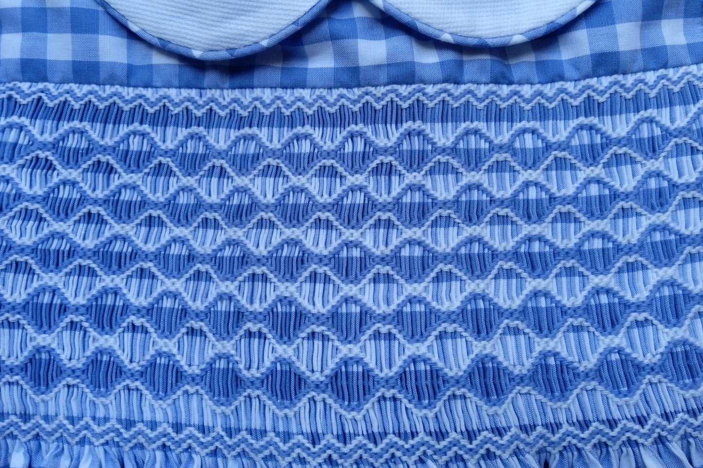 Close-up of hand-smocked detailing on Smocked Azure Gingham Dress, featuring vibrant blue gingham patterns.