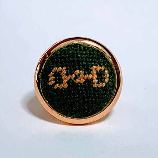 Green & gold needlepoint ring featuring a snaffle bit design, perfect for horse lovers and equestrian gifts.