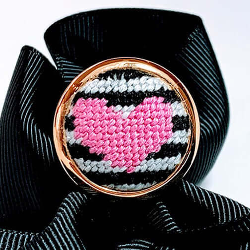 Pink heart needlepoint ring on a black ribbon, fully adjustable and stylish for any occasion. Perfect as a unique gift!