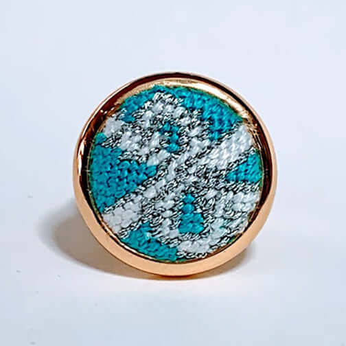 Iconic Blue Box Needlepoint Ring with unique design in turquoise and white, featuring a rose gold adjustable band.